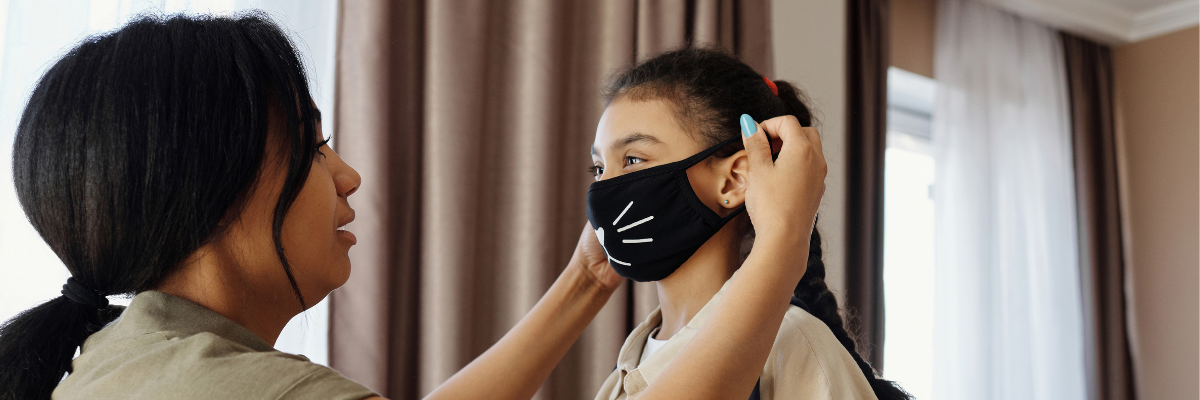 AIM-Research-Policy-Header Researcher places a cat themed mask on a child's face