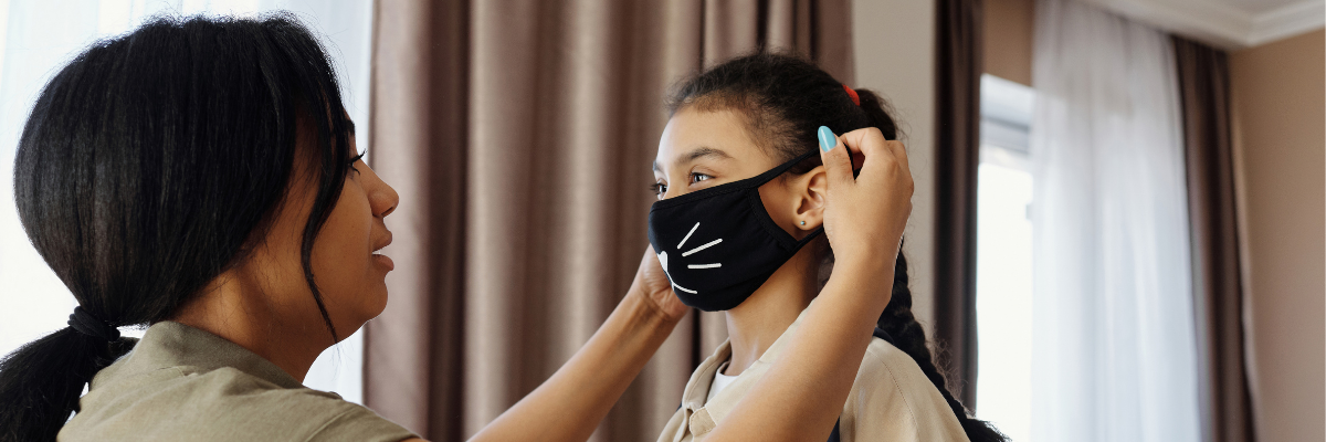 Researcher places a cat themed mask on a child's face