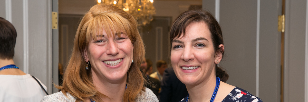 About-AIM-Header AIM Staff members smiling at an event